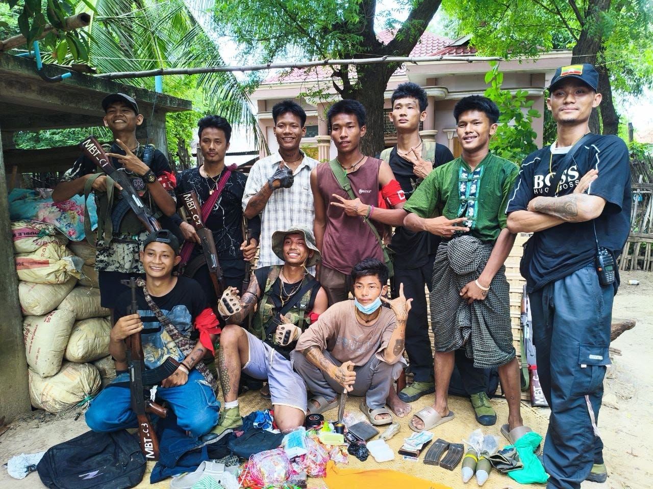 A group of armed men pose in casual clothes