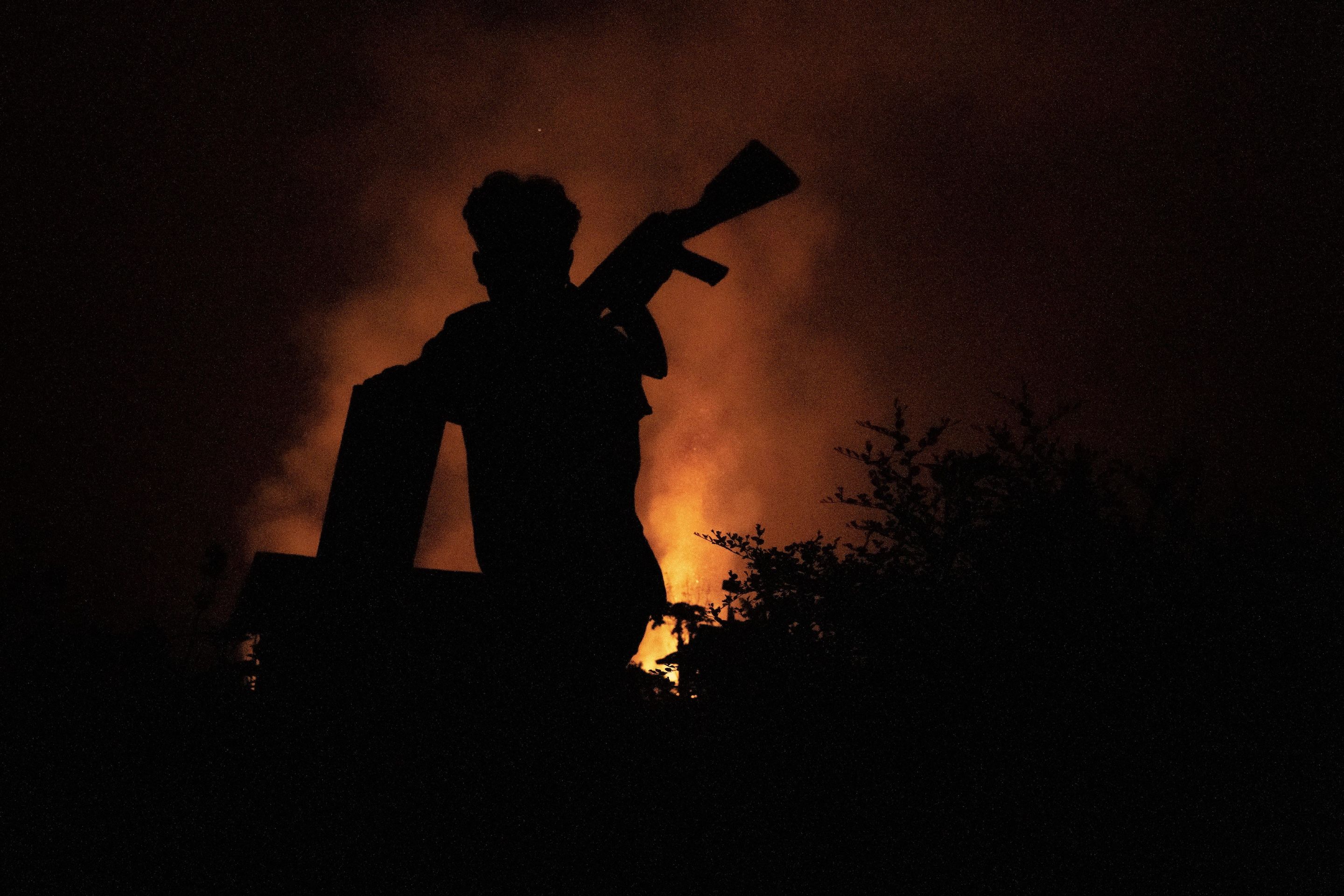 A silhouette of a soldier in front of a fire